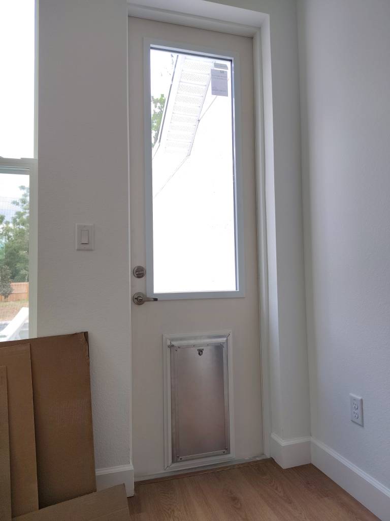 New door with built-in dog door and locking security panel installed, interior view